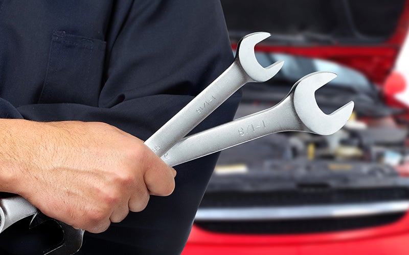 mechanic holding wrenches